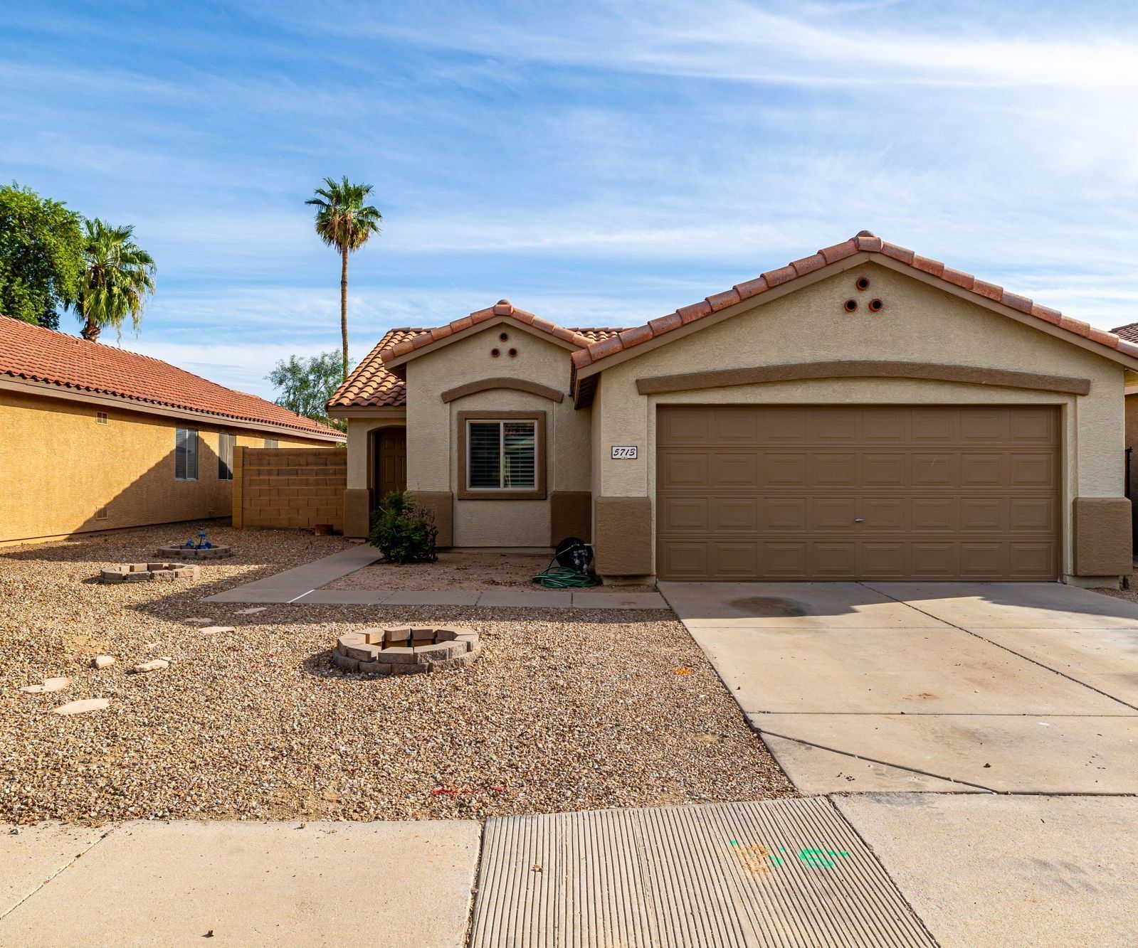 Single-story home with a two-car garage and desert landscaping